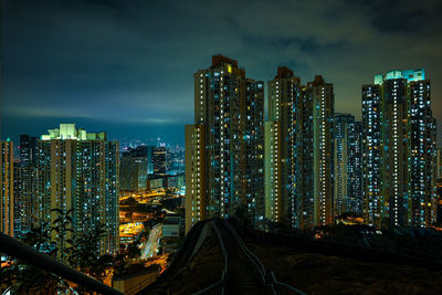 Illuminated buildings in city against sky at night