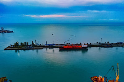 Fishing boats on pier at harbor against sky