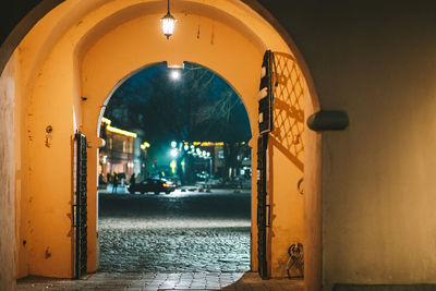 Illuminated street seen through door of building