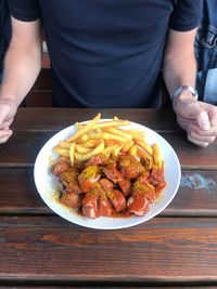 Midsection of man having food at table