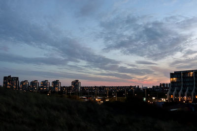 High angle view of illuminated buildings against sky at dusk