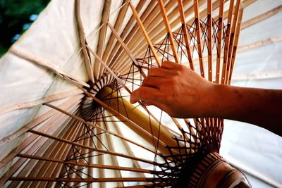 Cropped hand of person making umbrella