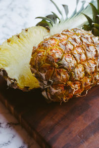 Halved pineapple on cutting board