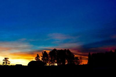 Silhouette trees against sky at sunset