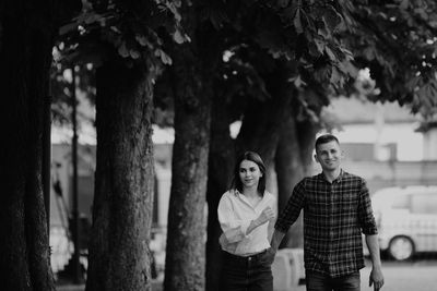 Portrait of friends standing against trees