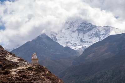 Scenic view of building and mountains against sky