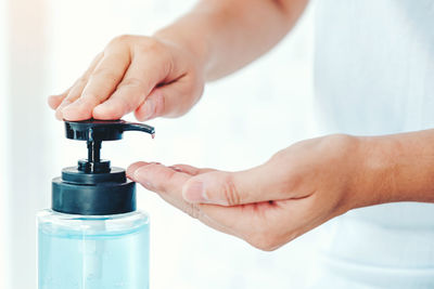 Close-up of hand holding glass bottle