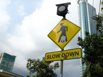 Low angle view of road sign against sky