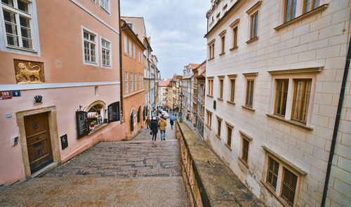 Rear view of people walking on building in city