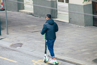 Rear view of man standing on footpath