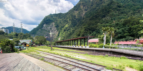 Train on railroad track by mountain against sky
