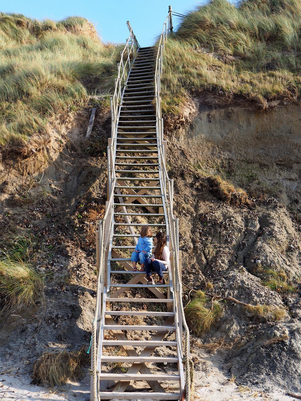 PEOPLE ON STEPS BY FOOTBRIDGE