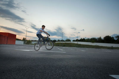 Side view of man riding bicycle on road