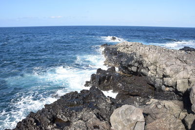 Scenic view of rocks in sea against sky