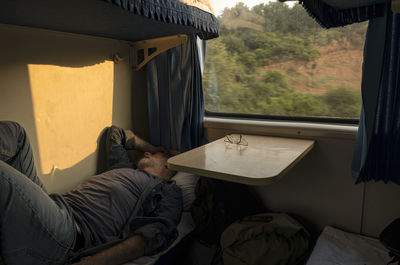 Caucasian man lying on bed in train. china
