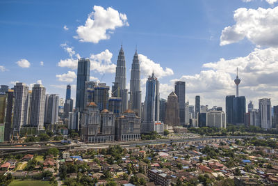 View of cityscape against cloudy sky