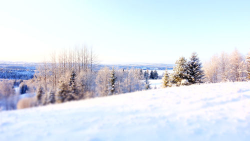 Snow covered field against clear sky