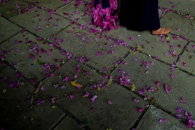 Low section of man with pink flowers