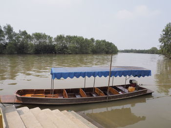 Boats moored in lake against sky