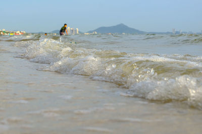 People at beach against sky