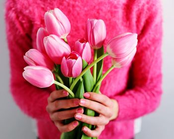 Close-up of woman holding pink flower