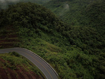 Countryside road passing through the lush green tropical rain forest mountain landscape