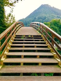 Staircase leading towards mountain against sky