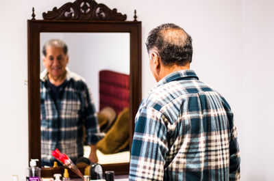 Man standing against mirror at home