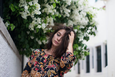 Beautiful woman standing against plants in city