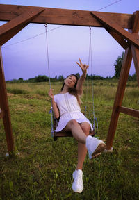 Full length of woman sitting on swing