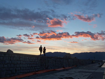 Silhouette man standing against sky during sunset