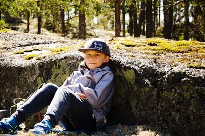 Boy sitting on rock