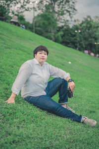 Young man sitting on grassy field