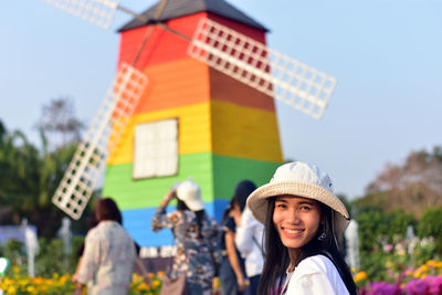 Portrait of smiling young woman against colorful lighthouse