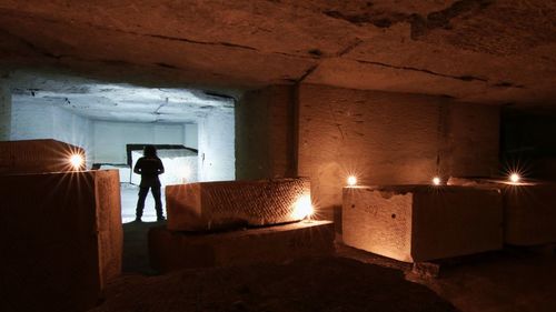 Rear view of man working in illuminated room