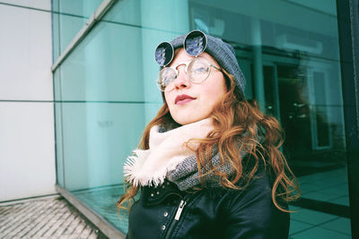 Portrait of woman standing against wall in winter