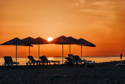 Silhouette people on beach against sky during sunset