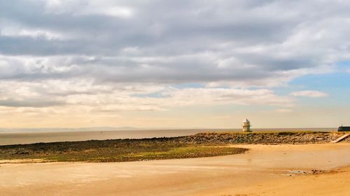 View of beach against cloudy sky