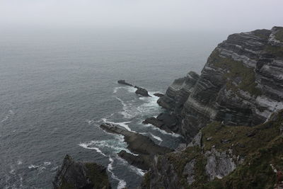 Scenic view of irish cliffs against the gray sky and sea