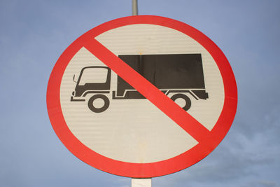 Close-up of road sign against sky