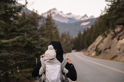 Rear view of woman carrying child