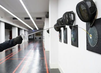 Woman's hand with fencing sword hitting target at gym