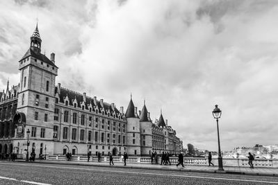 Buildings in city against cloudy sky