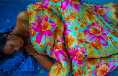 High angle view of woman sleeping on bed