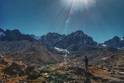 Man standing on land against sky during sunny day