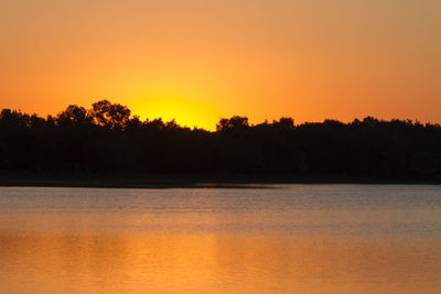 Scenic view of lake against orange sky