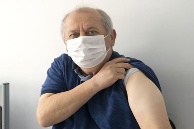 Portrait of man wearing mask against white background