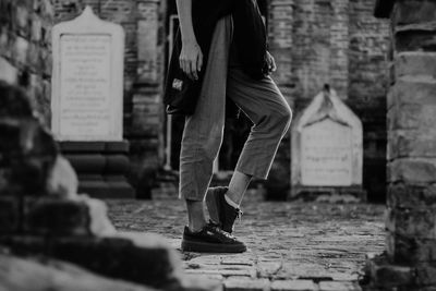 Low section of man walking on paving stone