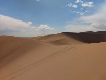 Sand dunes in desert against sky