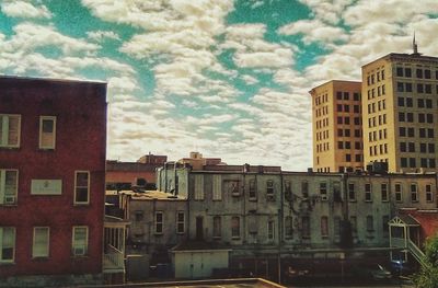 Low angle view of buildings against cloudy sky